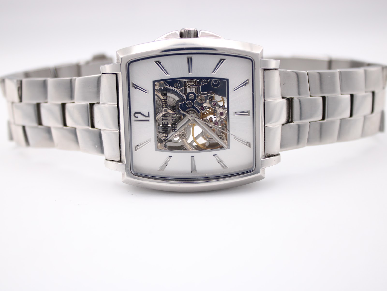 The watch laid flat, showcasing the full length of the stainless steel bracelet and the square case design.