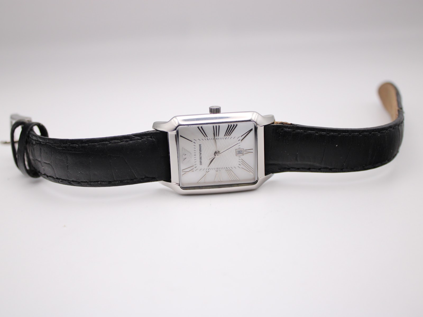 Overhead view of the Emporio Armani AR-0413 watch lying flat, displaying the full length of the black leather strap and rectangular case.
