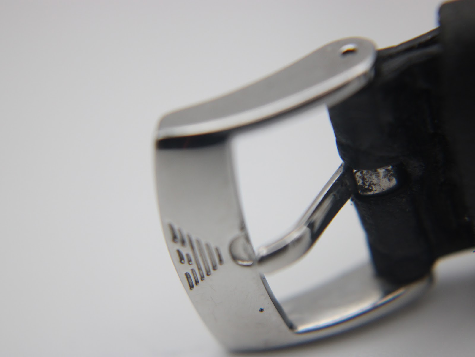 Close-up of the original stainless steel pin buckle of the Emporio Armani watch, showing the embossed eagle logo.