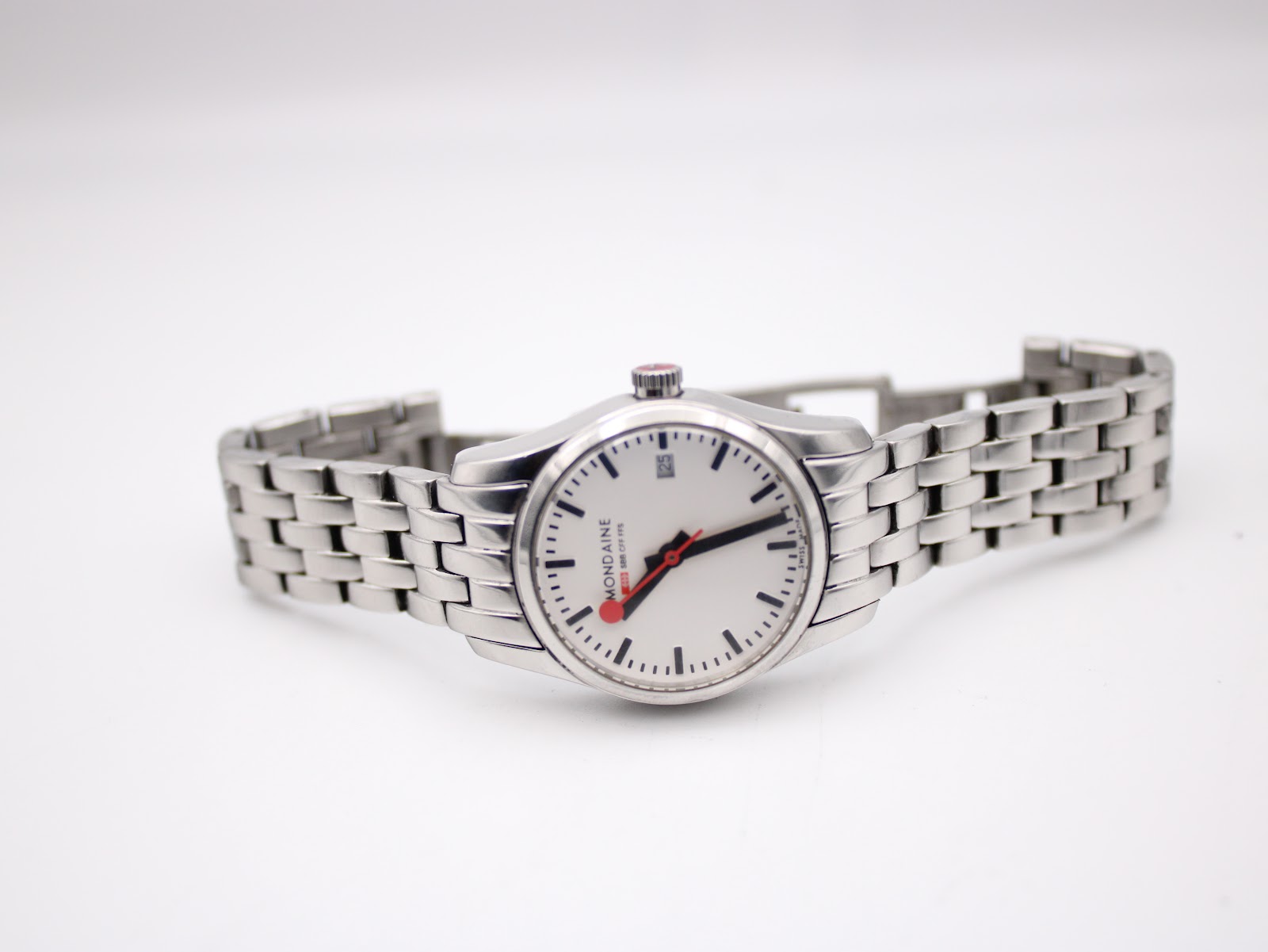 Full length view of the Mondaine watch laid flat, showcasing the entire stainless steel bracelet.