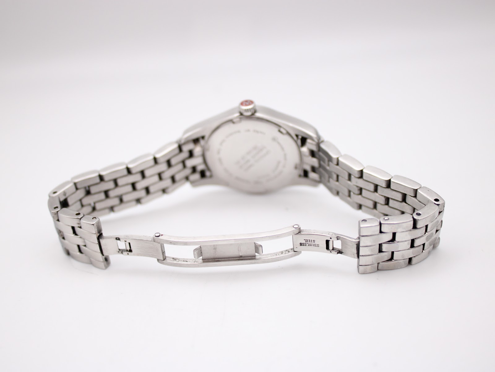 Rear view of the open stainless steel bracelet clasp, displaying the "Stainless Steel" engraving.