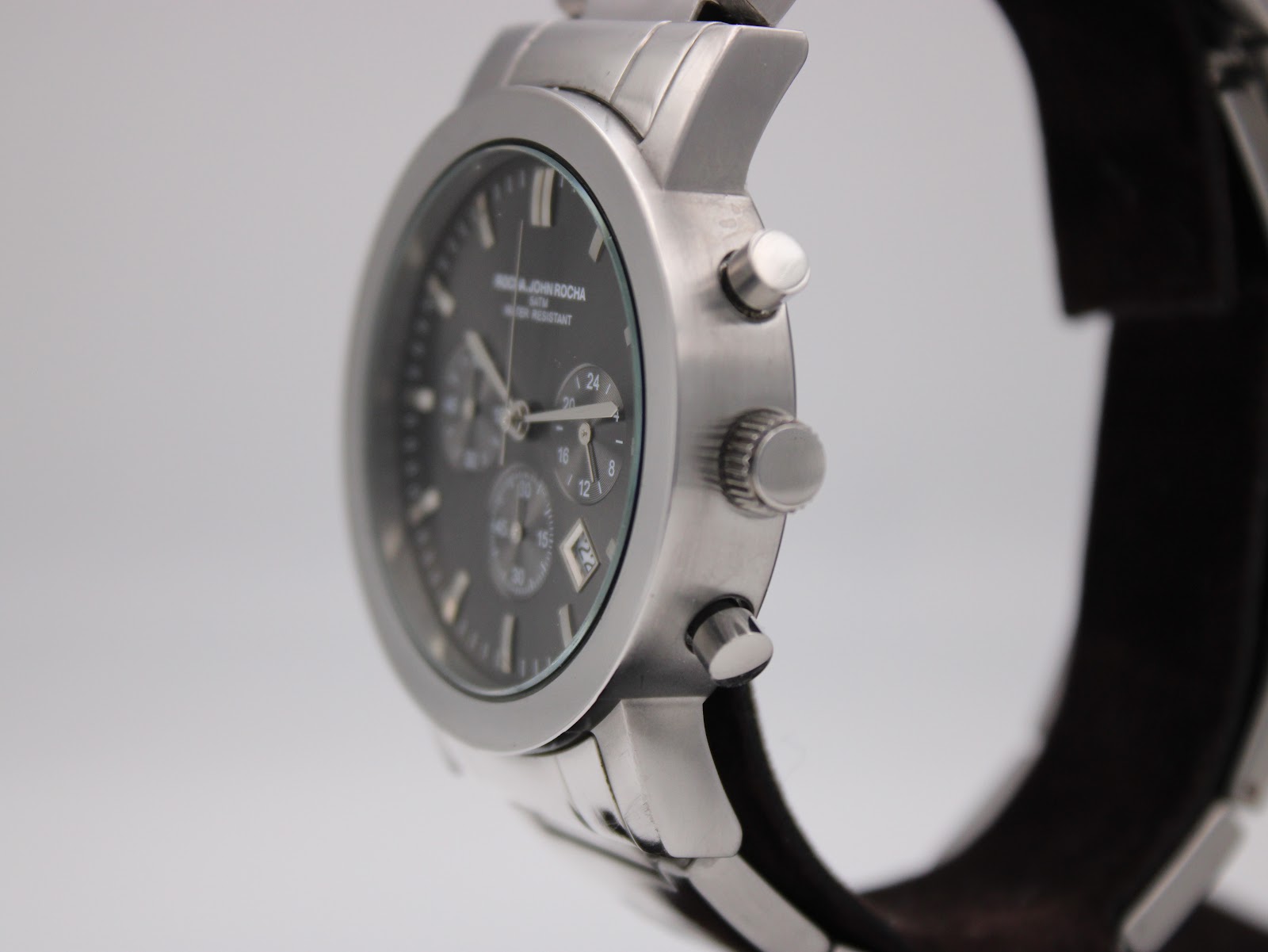 Side view of the Rocha John Rocha watch, highlighting the stainless steel case, crown, and chronograph pushers.