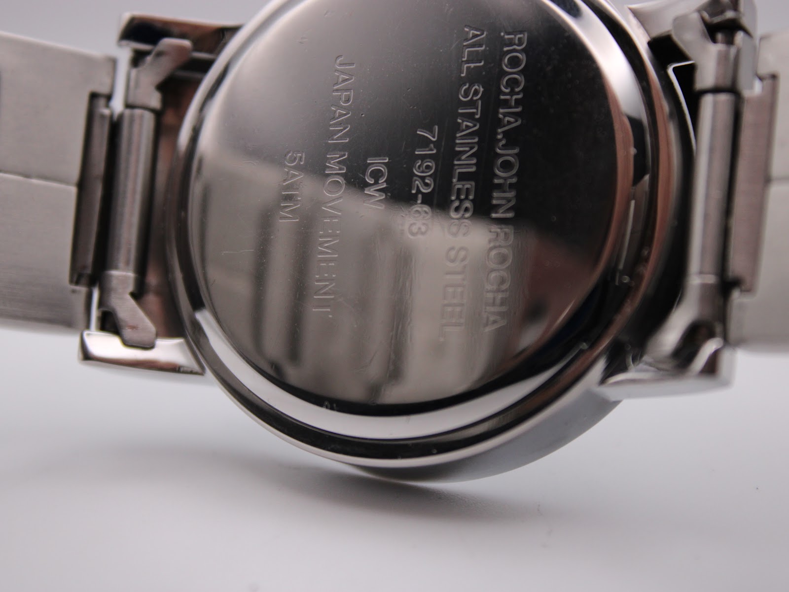 Close-up of the polished stainless steel case back, engraved with "ROCHA JOHN ROCHA ALL STAINLESS STEEL 7192-63 JAPAN MOVEMENT 5ATM".