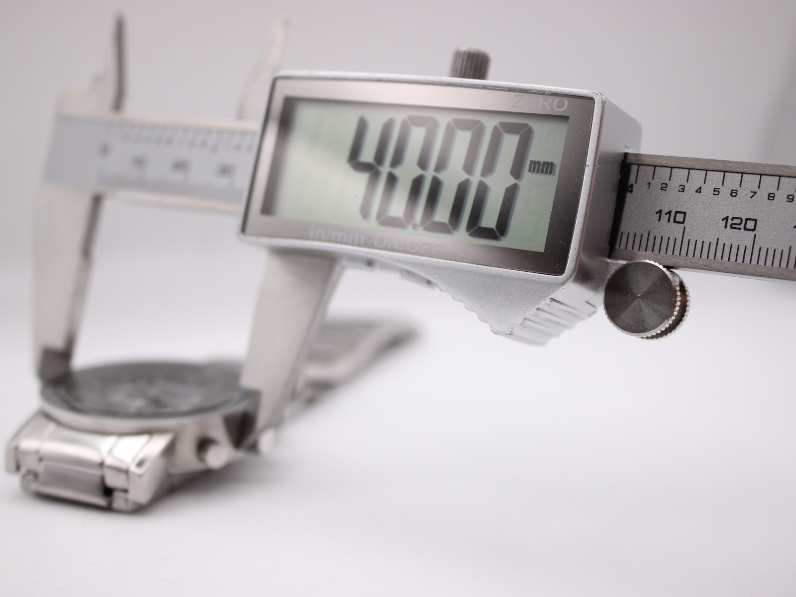 Digital caliper measuring the watch case diameter at 40.00mm, with the watch partially visible in the background.