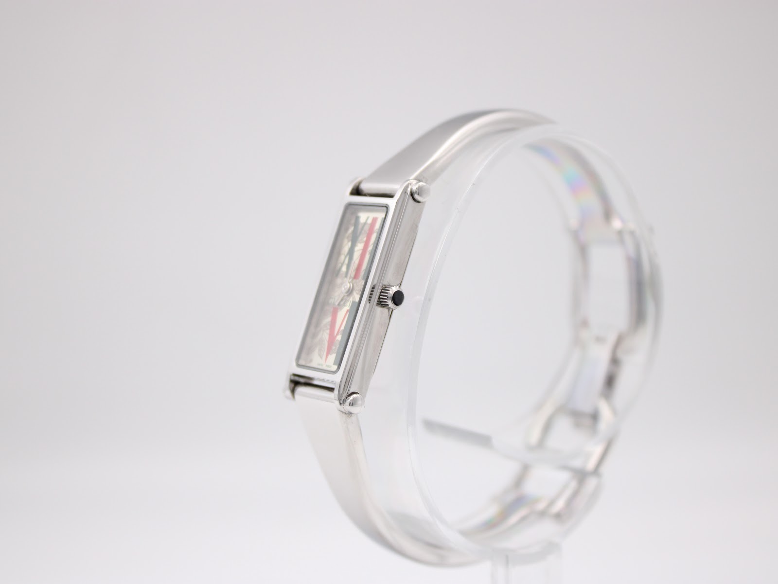 Right-side view of the Gucci 1500L watch on a display stand, highlighting the slim profile of the rectangular case and the original fluted crown.