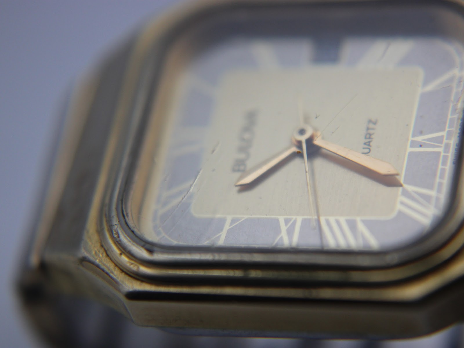 Close-up angled view of the Bulova P2 dial showing Roman numerals, brand name, and visible scratches on the mineral crystal.