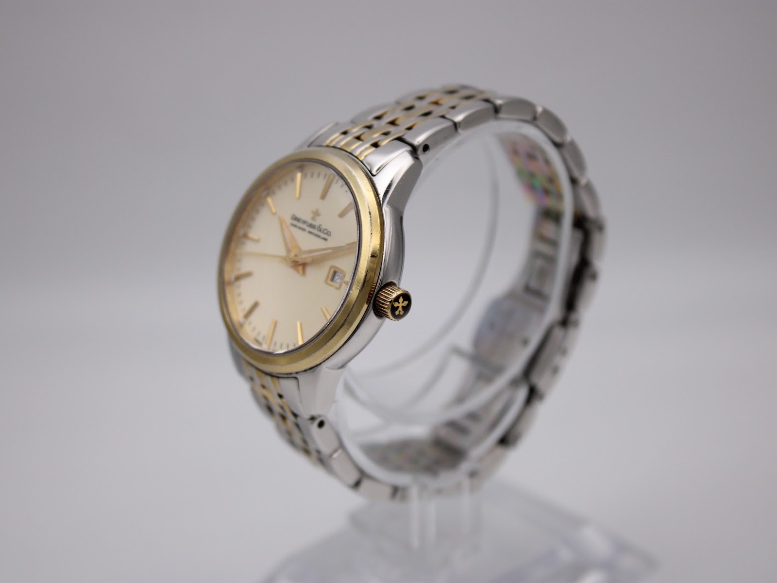 Angled side view of the Dreyfuss & Co. watch showing the gold bezel and two-tone bracelet.