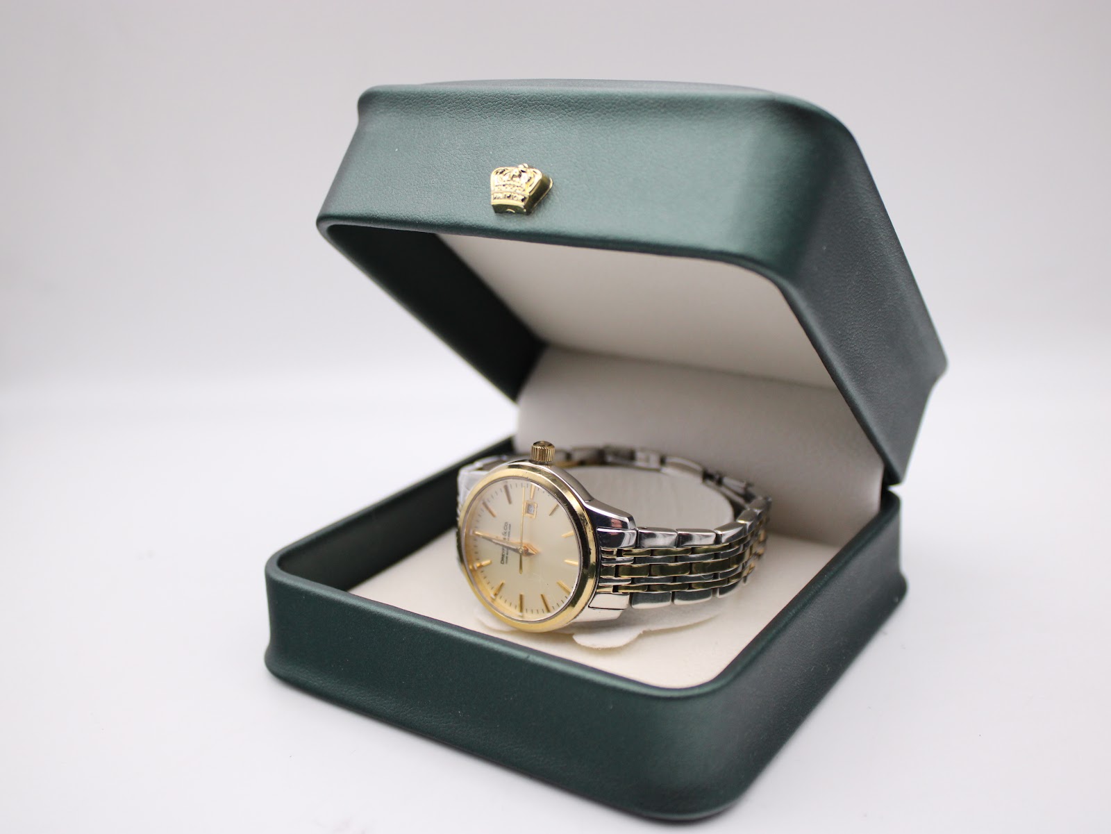 The Dreyfuss & Co. watch displayed in an open dark green box with a crown emblem.