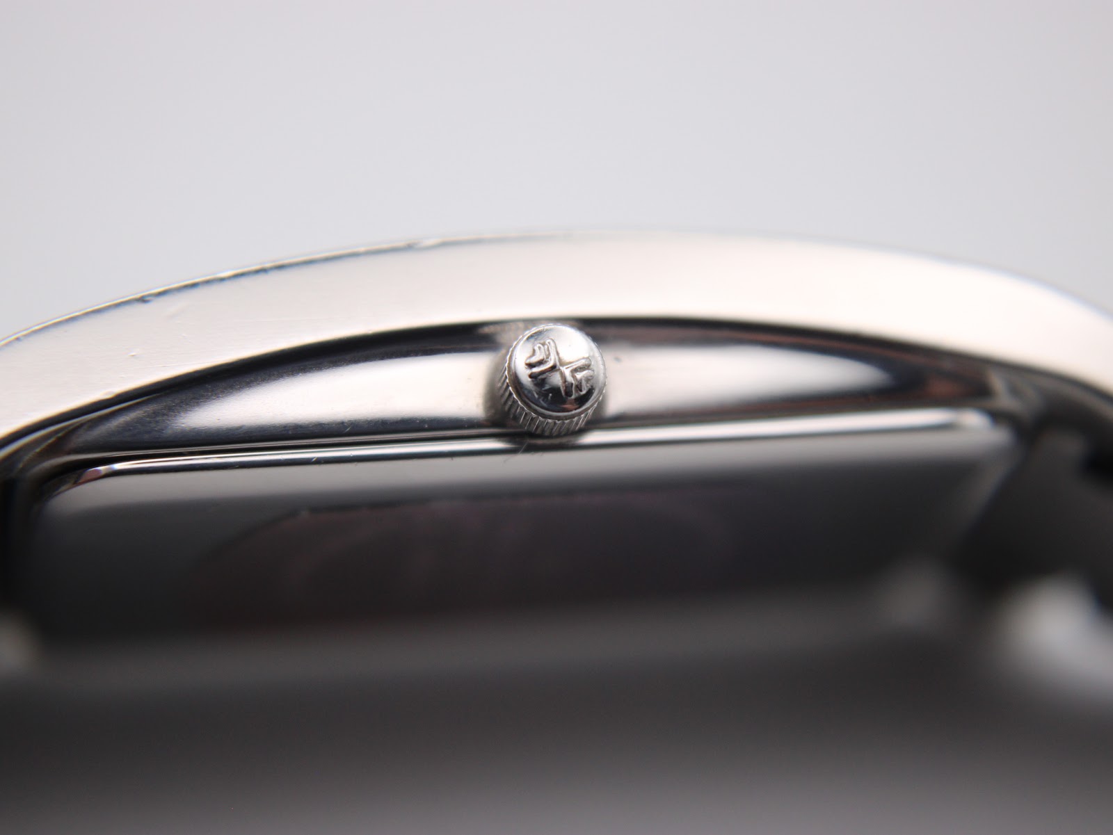 Extreme close-up of the watch's original crown, featuring the distinct Skagen logo engraving.