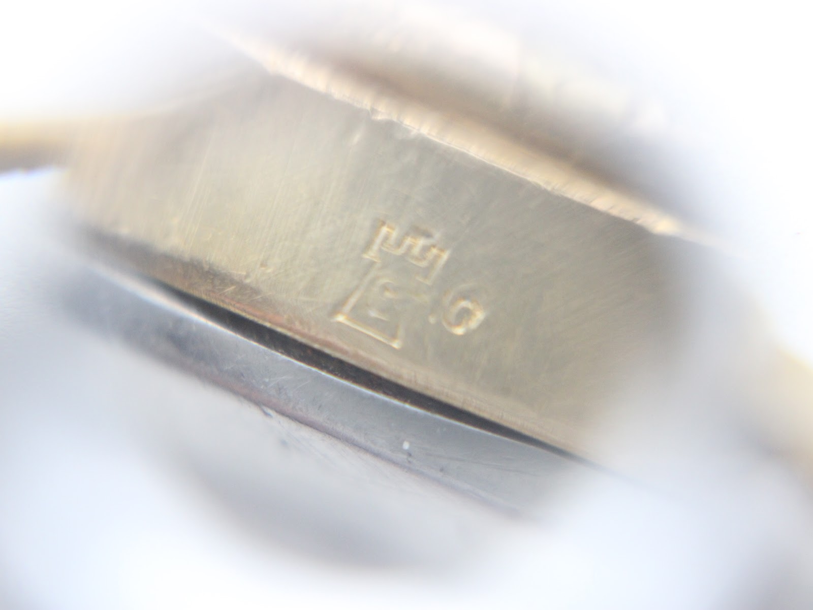 Macro shot of a subtle marking or engraving on the side of the watch case.