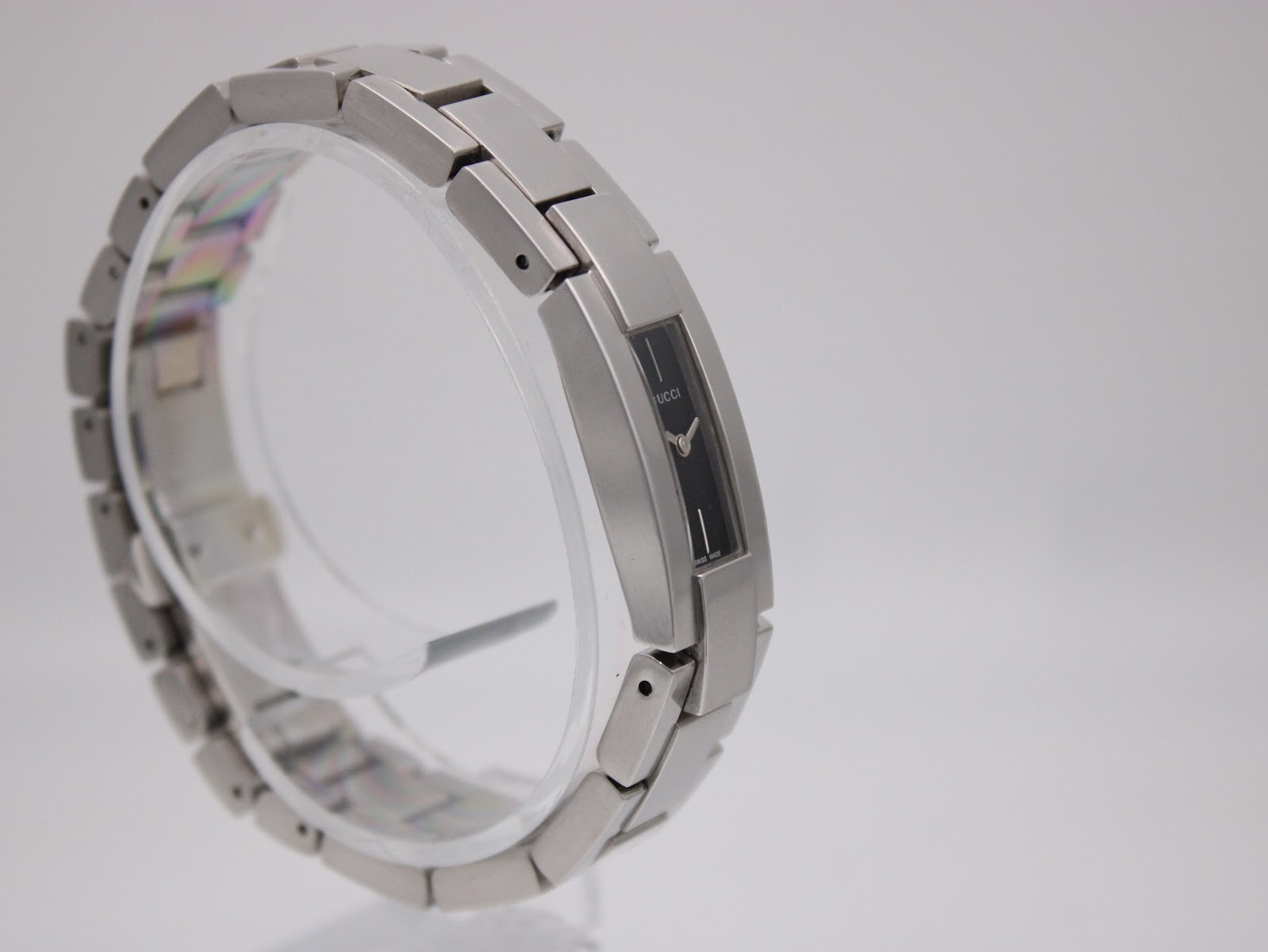 Angled side view of the Gucci 4600L on a clear stand, focusing on the sleek design and watch face.