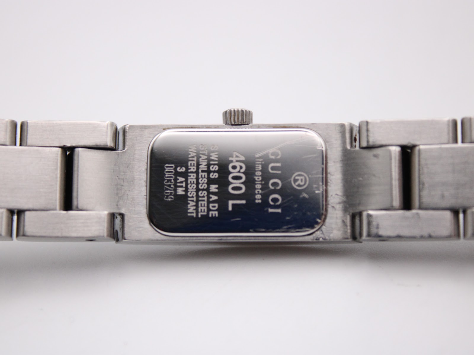 Close-up of the Gucci 4600L case back, displaying 'Gucci Timepieces Swiss Made 4600 L Stainless Steel Water Resistant 3 ATM 0003269' engravings.
