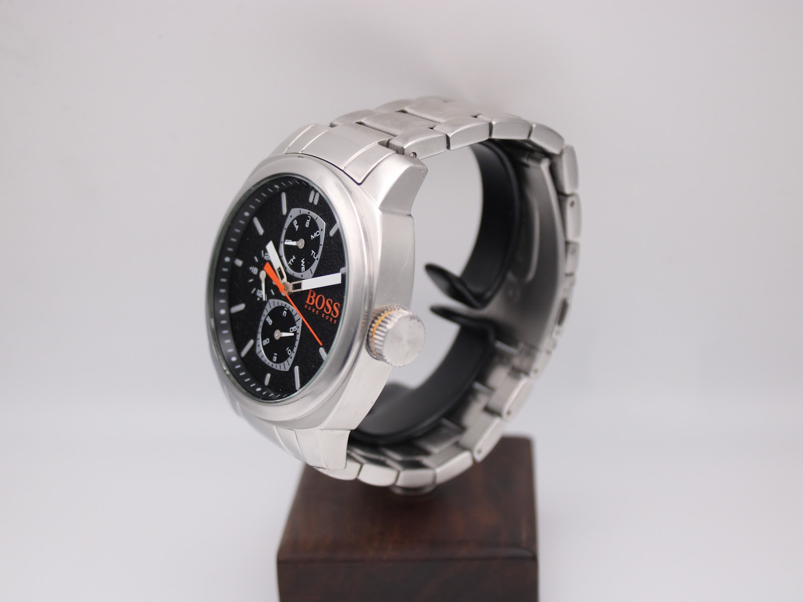 Right-side view of the Hugo Boss Orange watch on a stand, showing the stainless steel case, crown with orange detail, and bracelet.