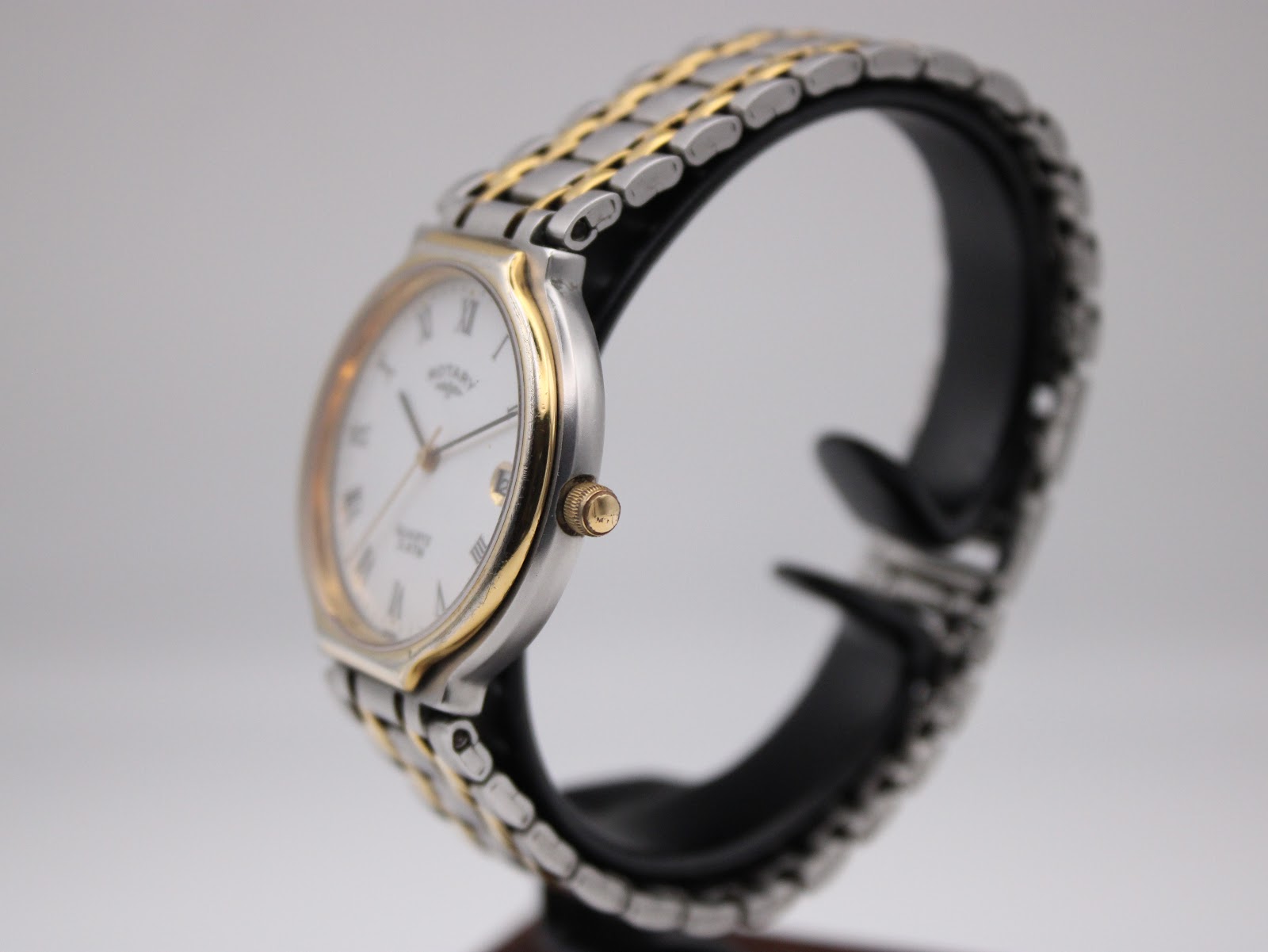 Side profile view of the Rotary 3705 watch on a stand, showing the gold-tone crown and bezel detail.