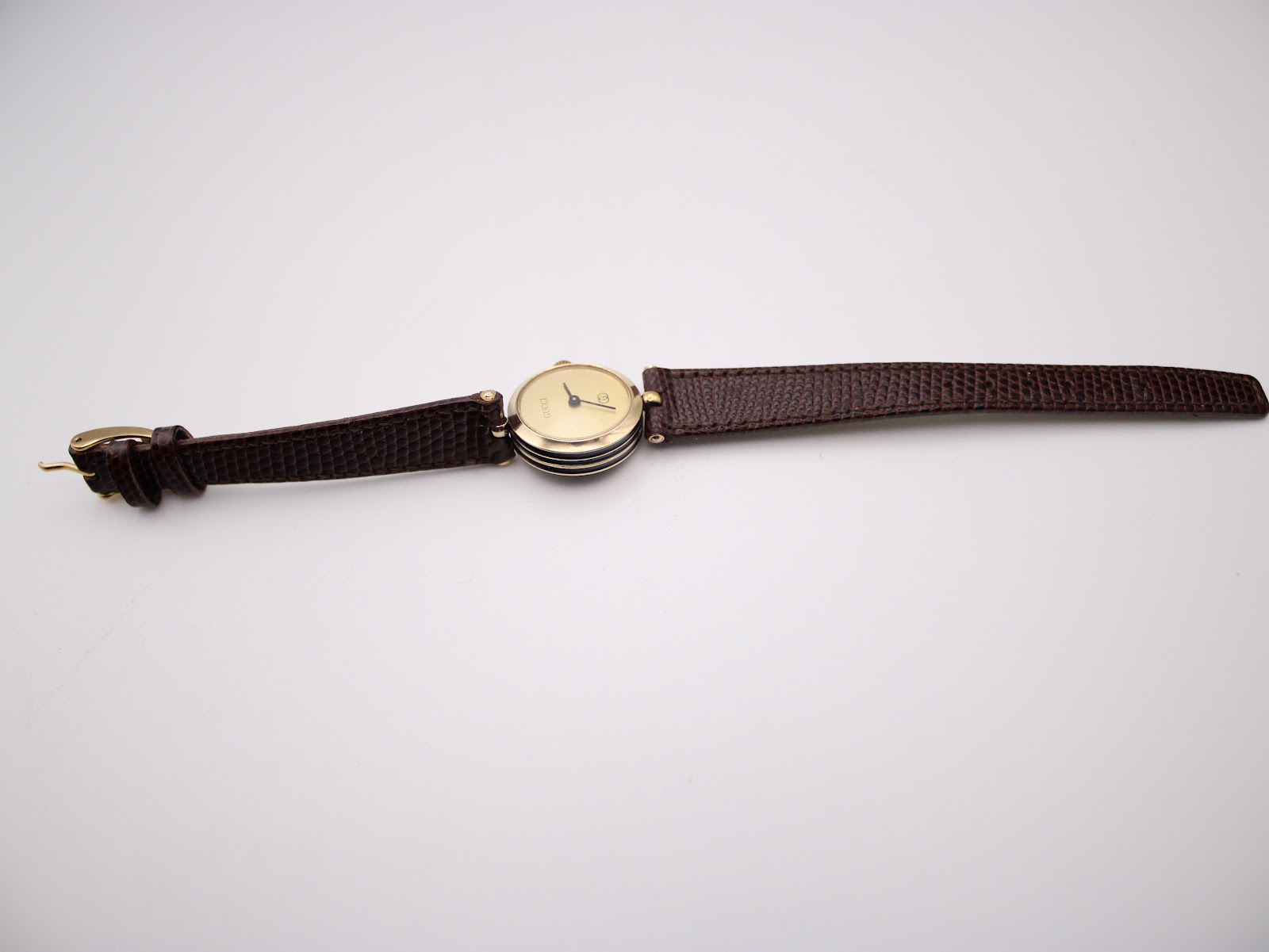 Opposite overhead view of the watch with the strap fully extended, highlighting the full length of the dark brown leather strap.