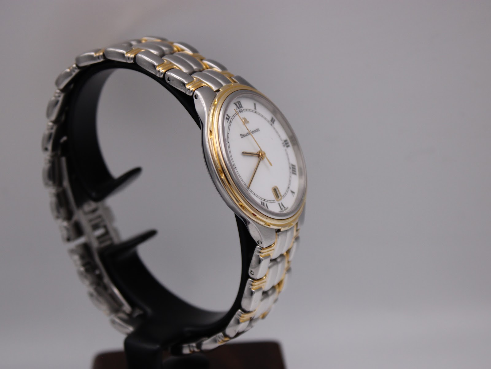 Angled side view of the Maurice Lacroix two-tone watch, highlighting the 'bamboo' style gold-plated bezel.