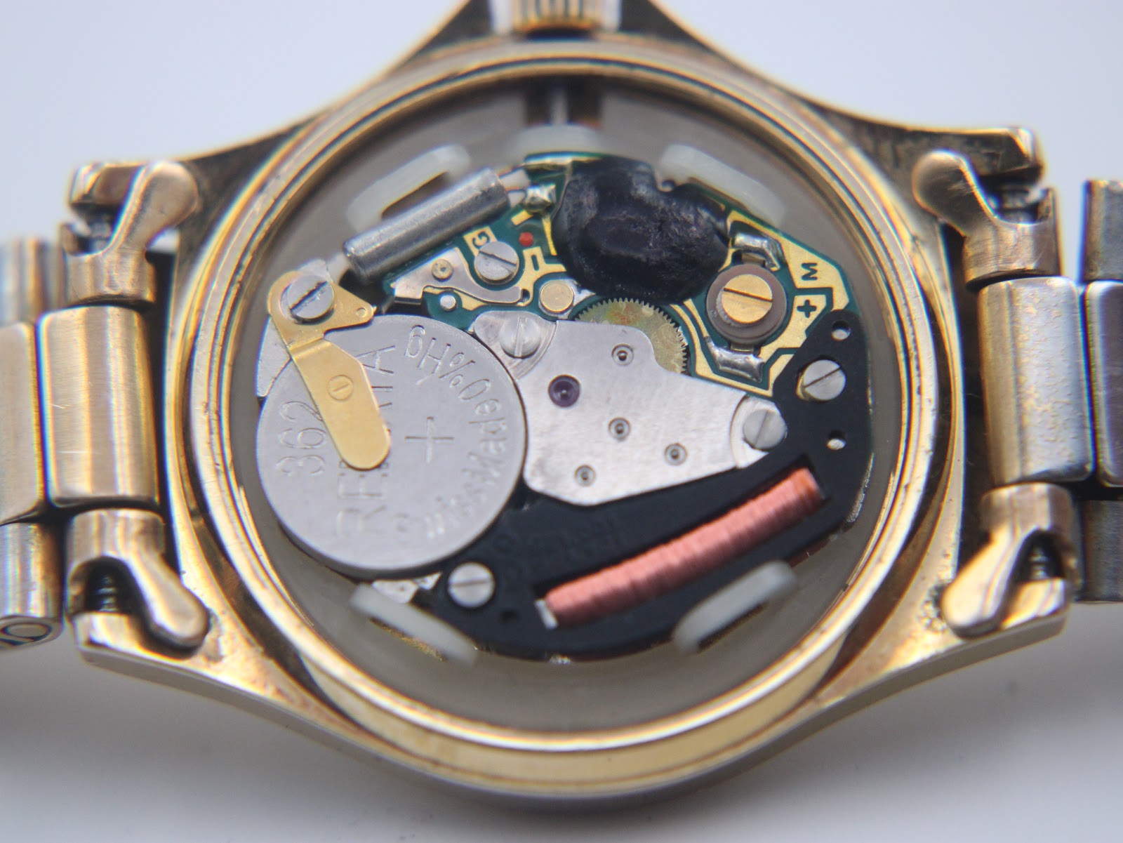 Close-up view of the Swiss quartz movement inside the watch, showing the battery and electronic components.