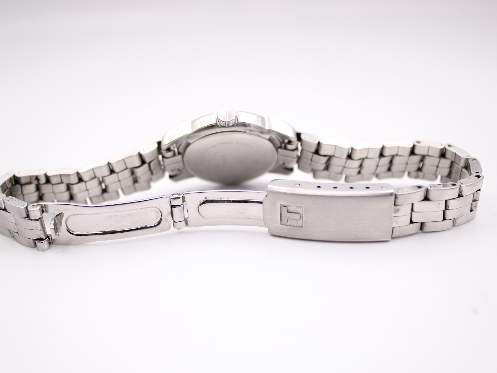 Underside view of the Tissot PR 50 stainless steel bracelet, revealing the fold-over clasp mechanism with the 'T' logo.