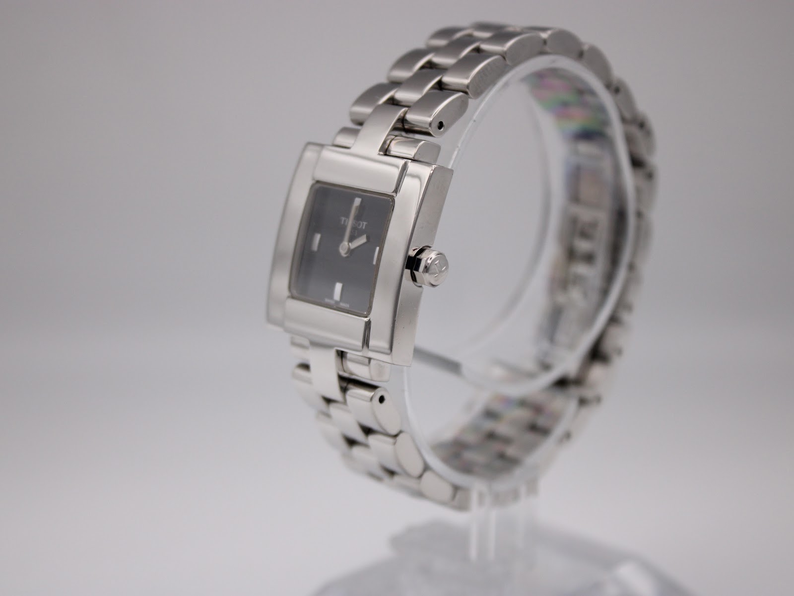 Angled side view of Tissot T-Trend ladies' watch on a display stand, showing the polished stainless steel case and bracelet.