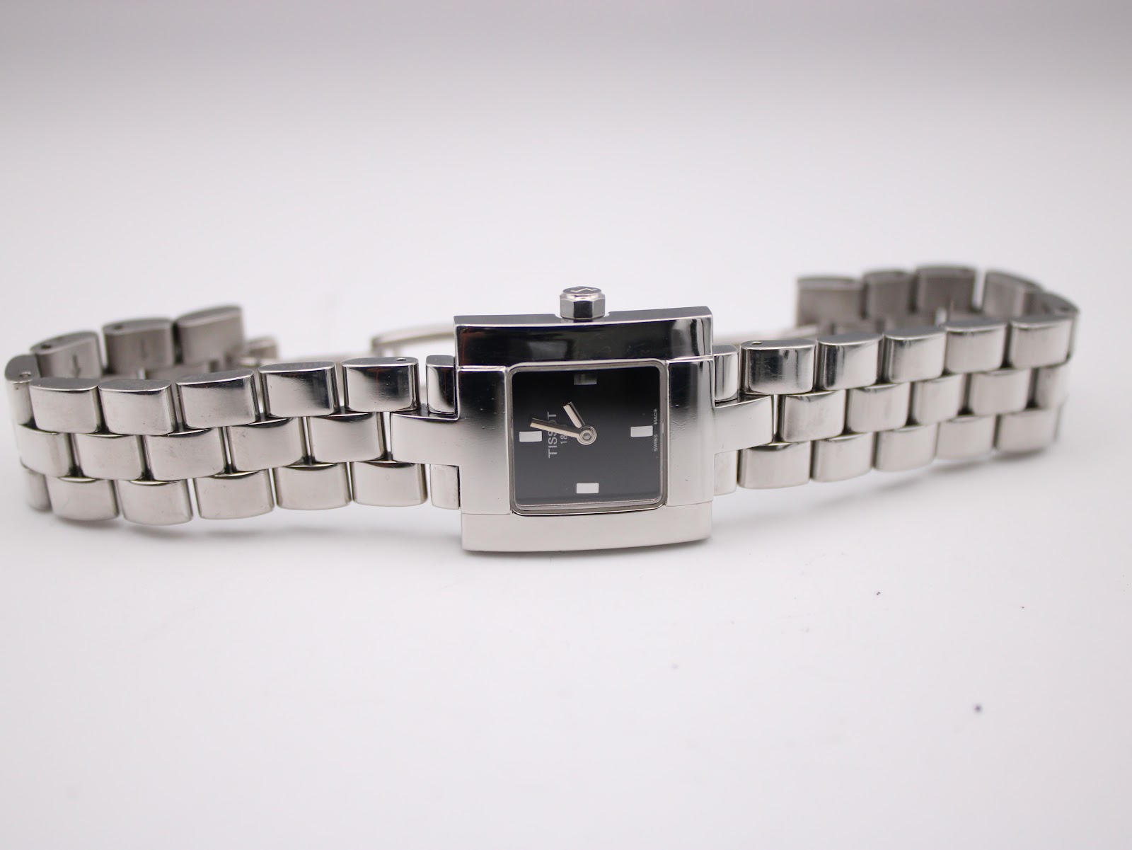 Overhead view of the Tissot T-Trend watch with its stainless steel bracelet laid out, showing the hidden butterfly clasp.