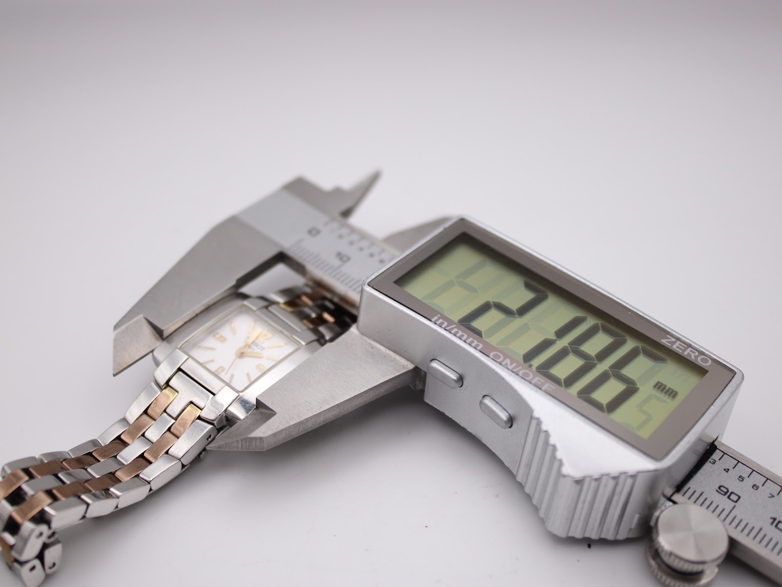 The Tissot T-Trend watch secured in a digital caliper, displaying a precise case width measurement of 21.86mm.