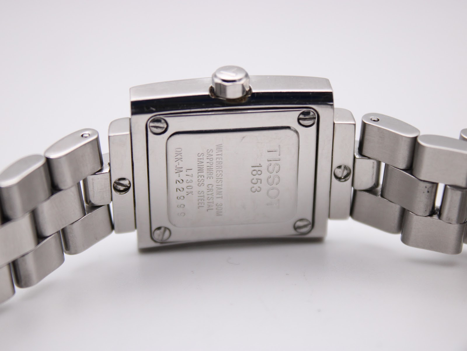 Close-up of the stainless steel case back of the Tissot L730K, showing model number, sapphire crystal, and 30m water resistance.