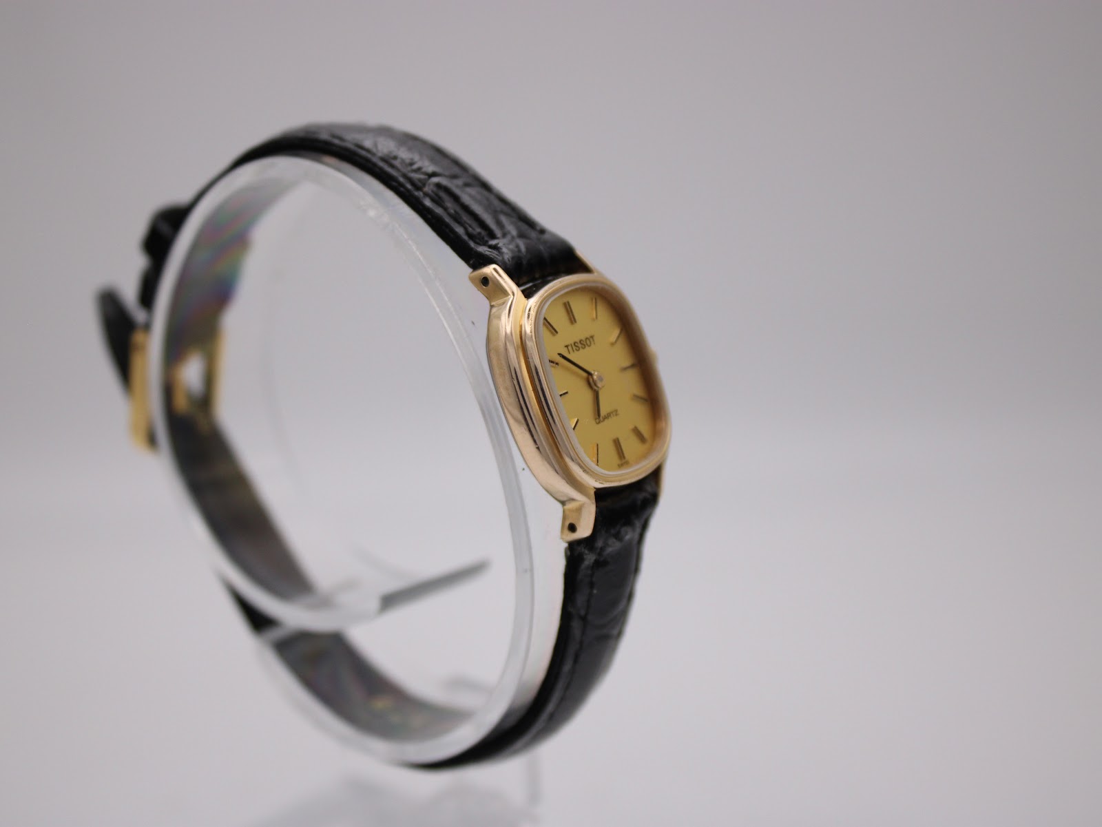 Close-up of Tissot gold dial with baton markers.
