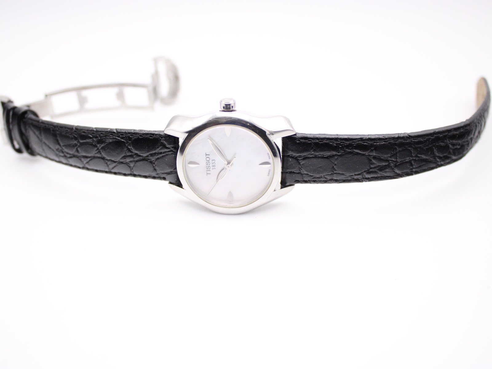 Overhead view of the Tissot T023210A watch with its black leather strap laid flat and the butterfly deployment clasp open.