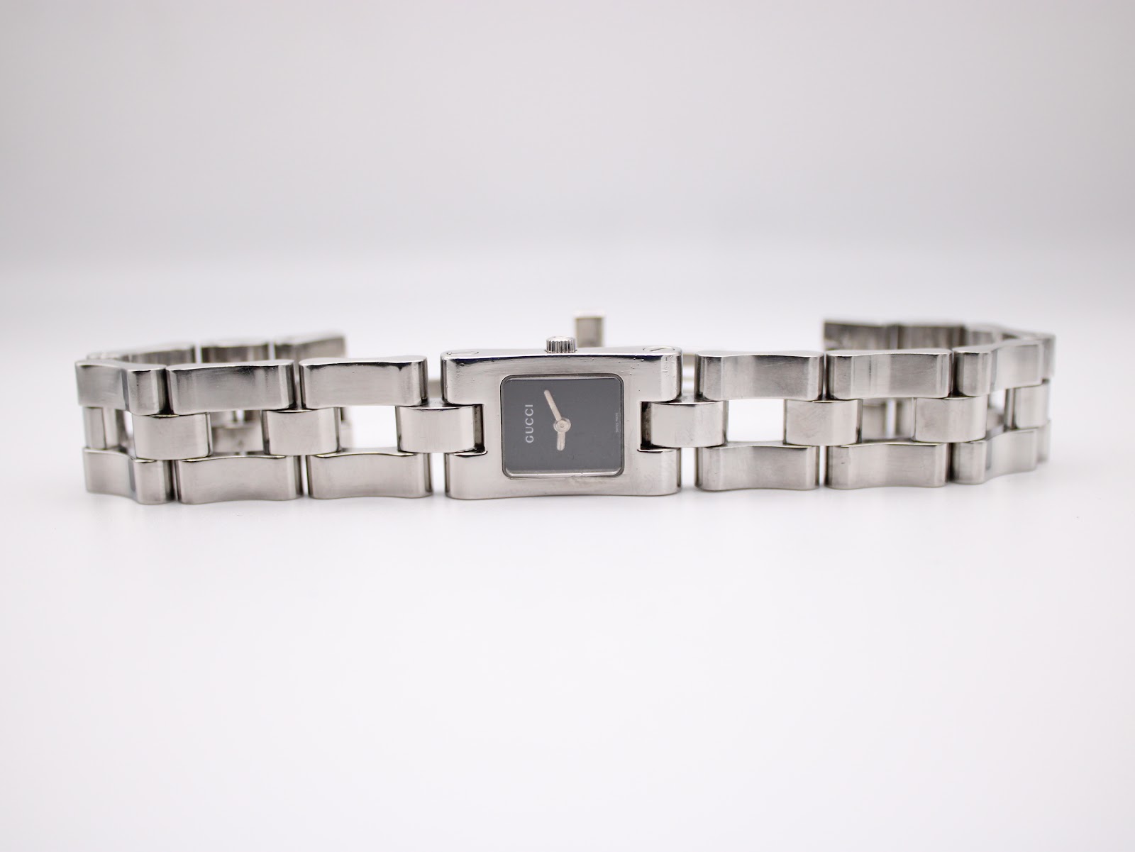 Top-down view of the Gucci 2300L watch with its stainless steel link bracelet laid flat.