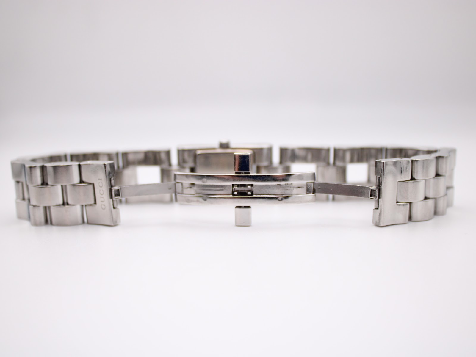 View of the Gucci 2300L's stainless steel bracelet opened, showing the butterfly clasp with 'GUCCI' branding.