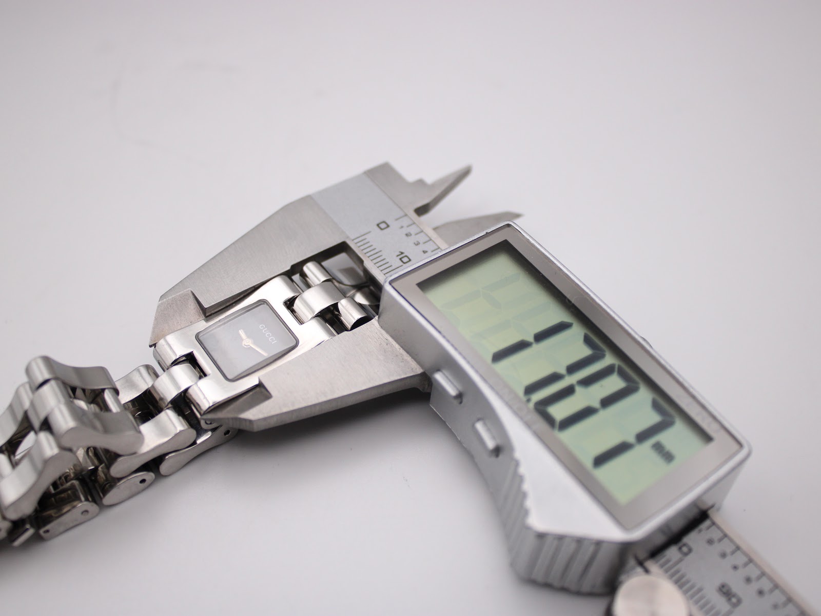 Close-up of a digital caliper measuring the case diameter of the Gucci 2300L, showing a reading of 17.07mm.