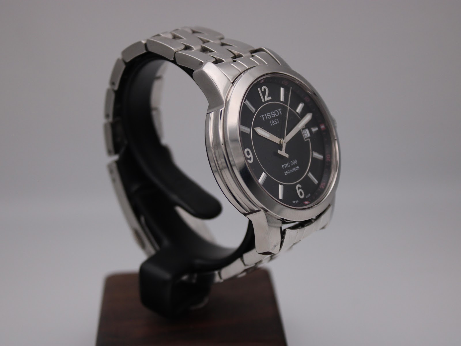 Another angled side view of the Tissot PRC 200 watch, showcasing the case profile and bracelet links.