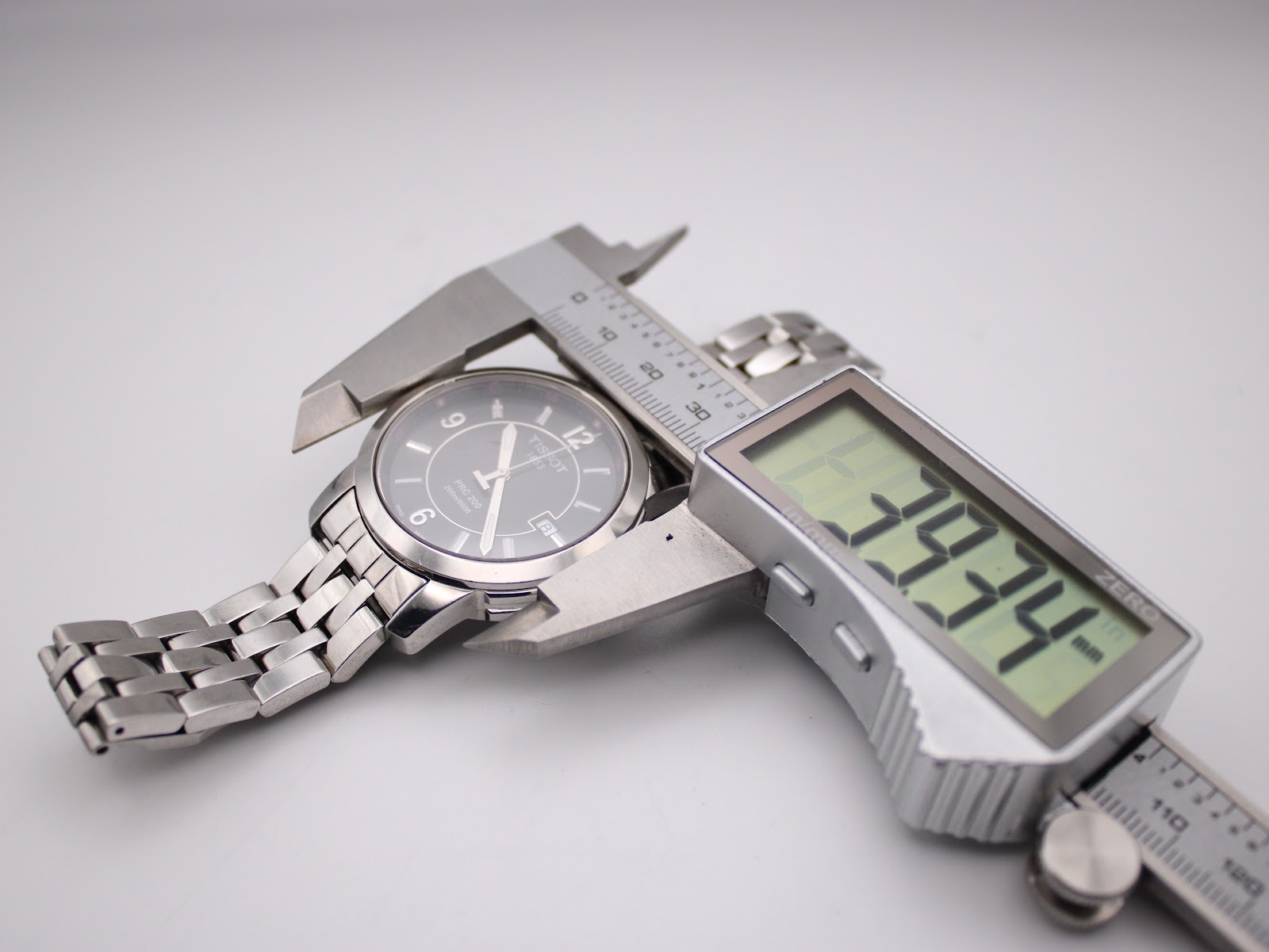 Digital caliper measuring the case diameter of the Tissot PRC 200, showing a precise reading of 39.34mm.