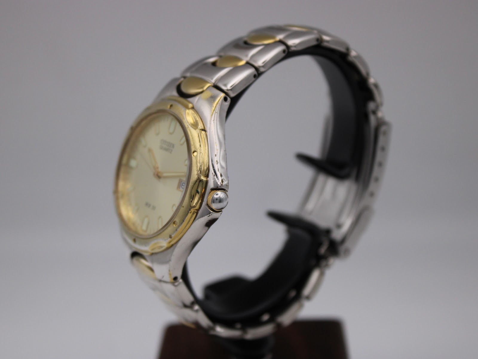 Side view of the Citizen two-tone watch showing the gold-tone crown and integrated bracelet.