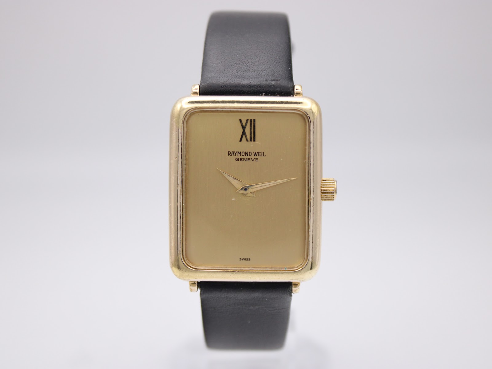 Another front view of the Raymond Weil 713 watch dial, showing the 'XII' Roman numeral and 'SWISS' text at 6 o'clock.